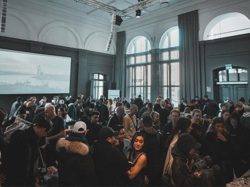 a large group of people in a room with a large screen