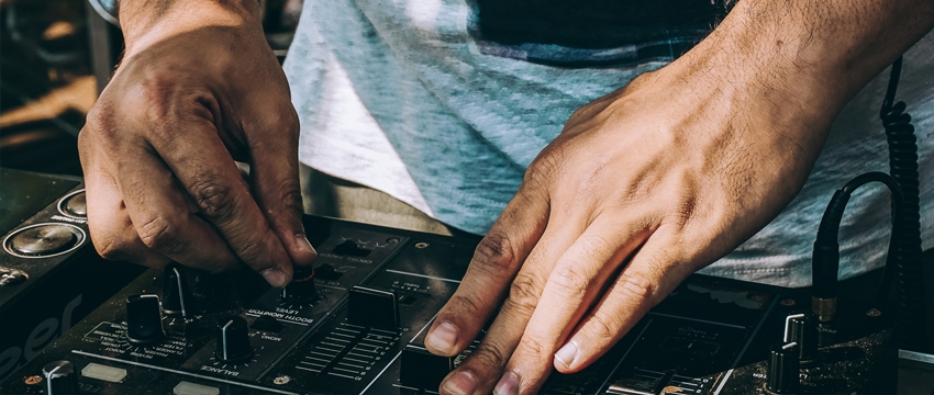 The hands of a dj on a dj mixer.