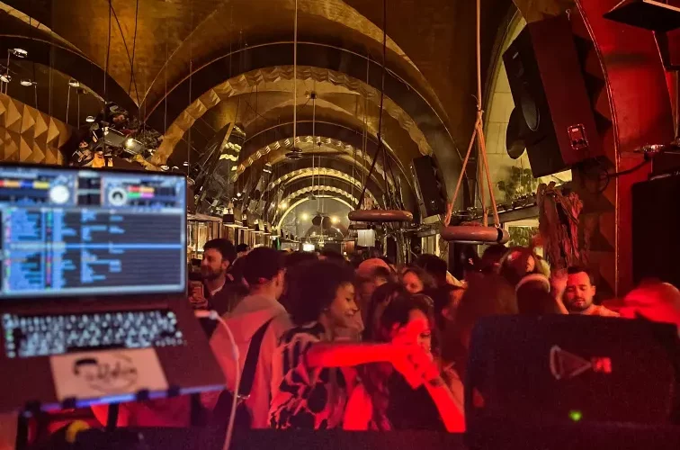 DJ Rakim playing music in a large room full of people